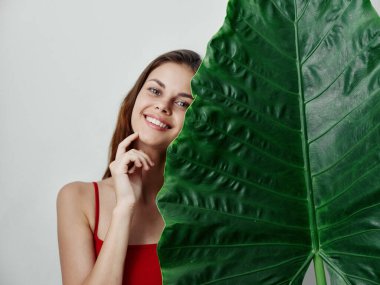 Gülümseyen kadın yeşil ardında egzotik bir cazibe bırakır.