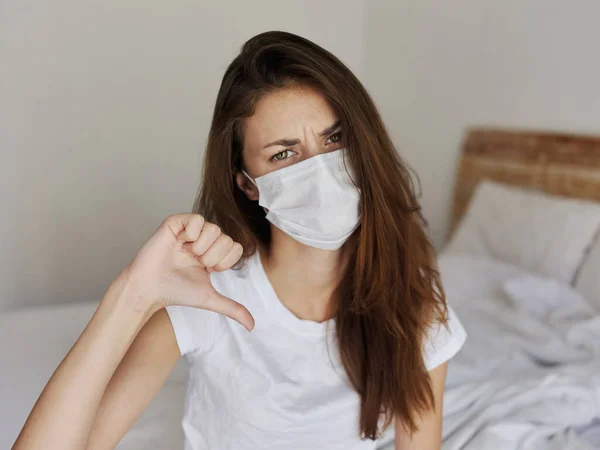 Woman with displeased facial expression showing thumb down medical mask — Stock Photo, Image