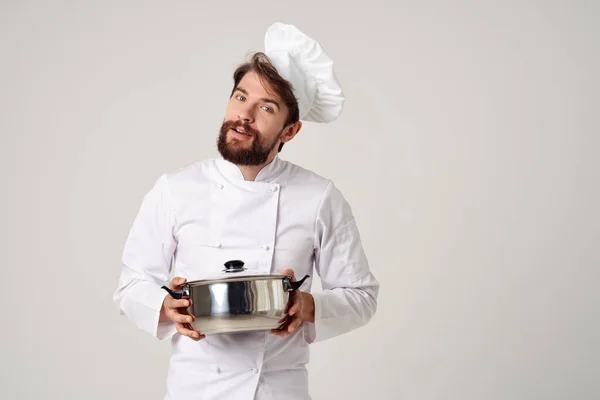 male chef with a cap on his head a saucepan in his hands kitchen cooking