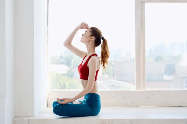 Женщина сидит рядом с окном йога тренировки гармонии — стоковое фото