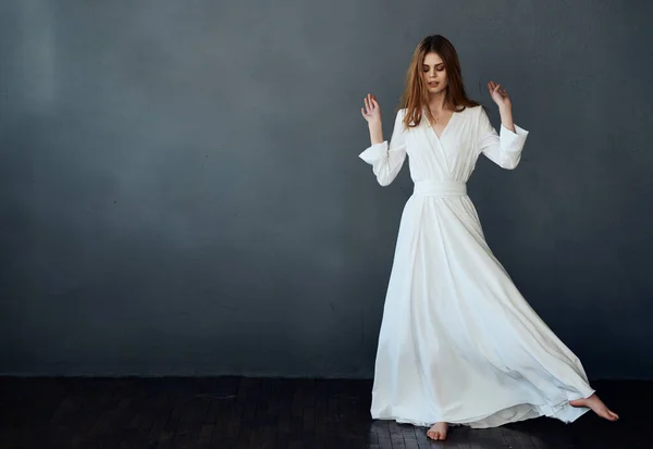 Bonita mujer bailando en blanco vestido estudio aislado fondo moda — Foto de Stock