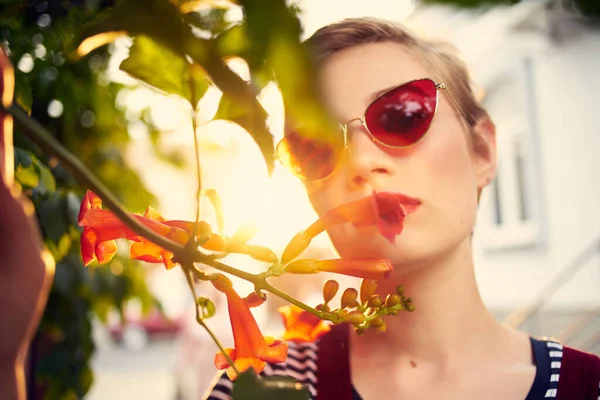 Vacker kvinna utomhus bär solglasögon blommor närbild — Stockfoto