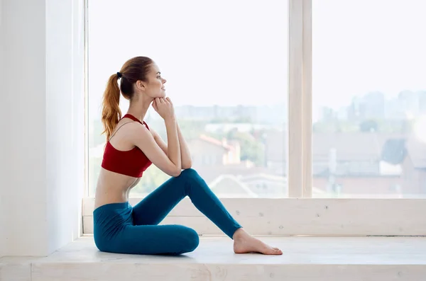 Kobieta robi jogę w pobliżu okna relaksu medytacja styl życia — Zdjęcie stockowe