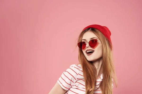Mujer joven de moda con gafas de sol ah-ah ropa casual posando fondo rosa — Foto de Stock