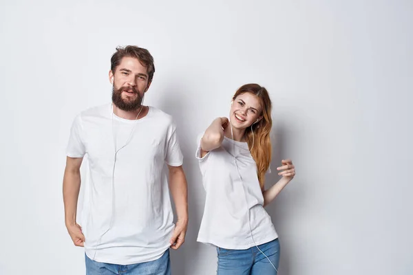 Muž a žena v bílých tričkách stojí vedle přátelství zábava světlo pozadí — Stock fotografie