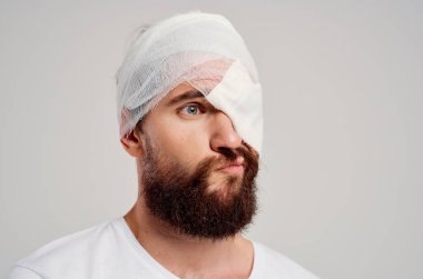 Kafası bandajlı ve gözü kanlı bir adam. Geçmişi izole edilmiş.