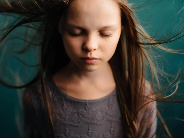 Menina com cabelo fluindo posando close-up fundo verde — Fotografia de Stock