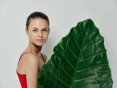 Kırmızı mayo giyen kadın çekici yeşil yaprak ışıklı arka plan