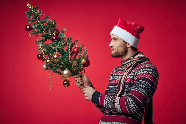 Elinde Noel ağacı olan adam oyuncaklarla Noel tatili süslüyor. — Stok fotoğraf