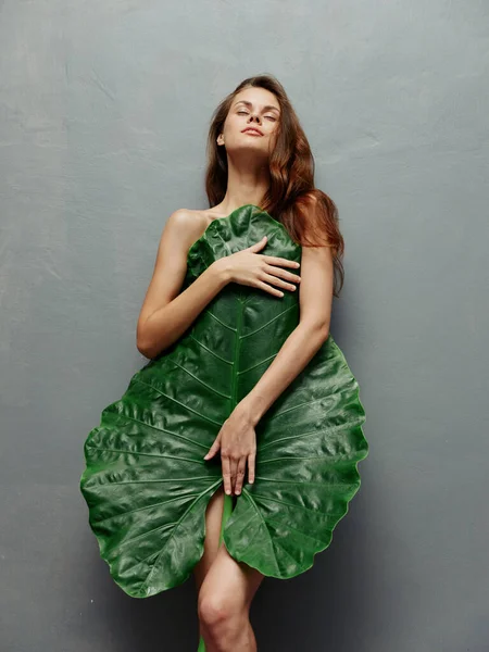 Kobieta z zamkniętymi oczami obejmuje nagie ciało i liście palmowe Egzotyczne odizolowane tło — Zdjęcie stockowe