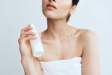 Çıplak omuzlu kadınlar cilt sağlığı yaşam tarzına losyon sürerler.