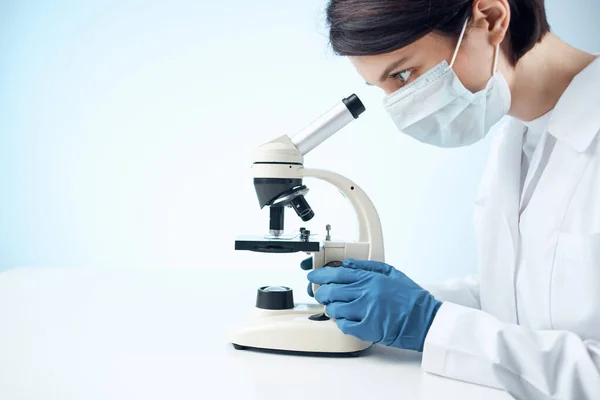 Γυναίκα βοηθός εργαστηρίου ιατρική μάσκα μικροσκόπιο διαγνωστική βιοτεχνολογία — Φωτογραφία Αρχείου