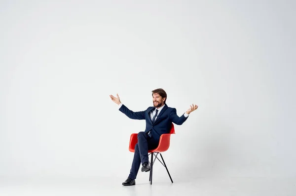 Homme d'affaires en costume assis sur chaise rouge émotions bureau amusant — Photo