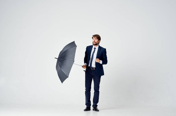 man in a suit with an umbrella in his hands protection from the rain elegant style full length