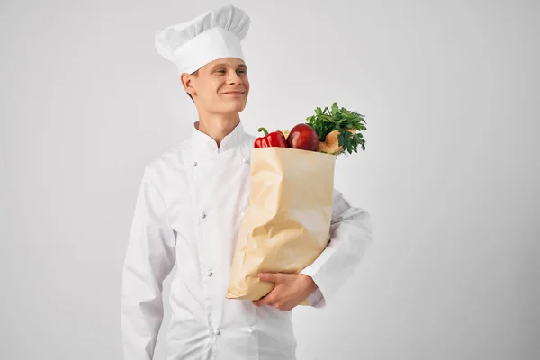 Un uomo in uno chef uniforme un pacchetto di prodotti servizio di lavoro — Foto Stock