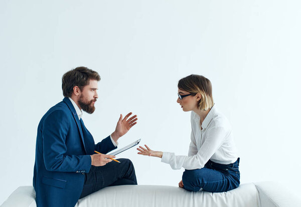man with woman sitting on a white sofa communication team office work