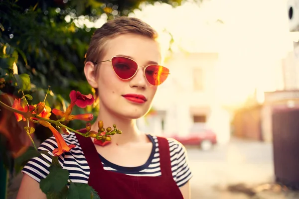 Kvinna i solglasögon på gatan nära blommor poserar livsstil — Stockfoto