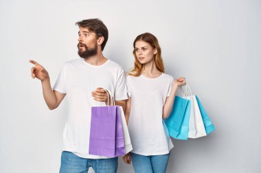 Tişörtlü genç bir çift indirimli alışveriş yapıyor.