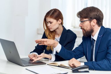 Meslektaşlarım dizüstü bilgisayar uzmanlarının önünde masa başında oturuyorlar.