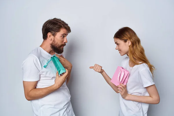 Pareja joven en camisetas blancas con regalos para los demás amistad — Foto de Stock