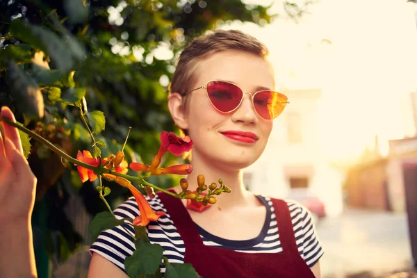 Vacker kvinna bär solglasögon blommor utomhus romantik livsstil — Stockfoto