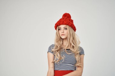 Kırmızı şapkalı güzel bir kadın. Çizgili tişört, modern tarz.