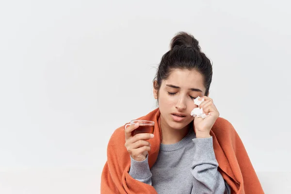 Vrouw zitten op de bank met een kopje thee en de behandeling van een koude ontevredenheid — Stockfoto