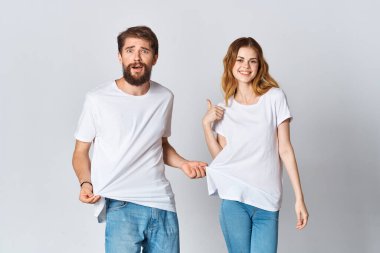 Beyaz tişörtlü ve kot pantolonlu erkek ve kadın moda fotokopi stüdyosu tasarlıyorlar.