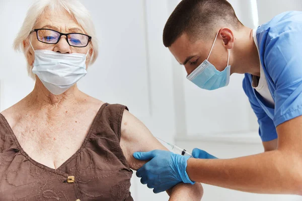 Läkare med ett spruta vaccin pass i medicinska masker — Stockfoto