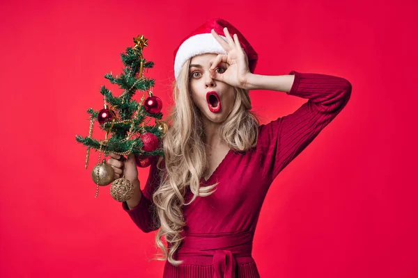 Όμορφη γυναίκα ντυμένη σαν Άγιος Βασίλης χριστουγεννιάτικο δέντρο παιχνίδια ροζ φόντο — Φωτογραφία Αρχείου