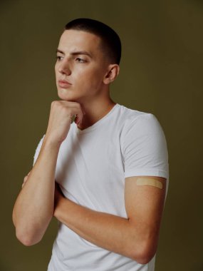 Siyah arkaplan aşısı pasaportlu beyaz tişörtlü bir adam.