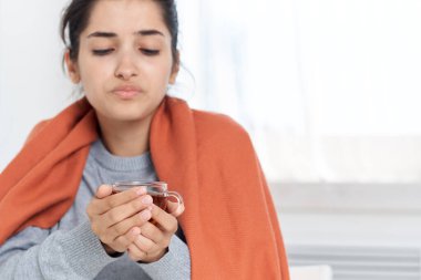 Soğuk çay içen hoşnutsuz bir kadın.