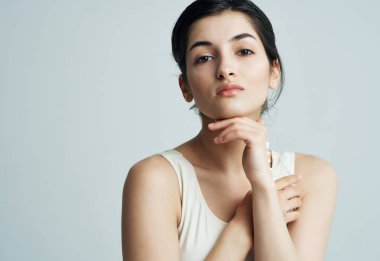 Ellerinde beyaz tişört kremi olan bir kadın. Sağlıklı bir cilt kremi.