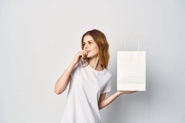 Kobieta make t-shirty z pakietem w rękach zakupy rozrywki — Zdjęcie stockowe