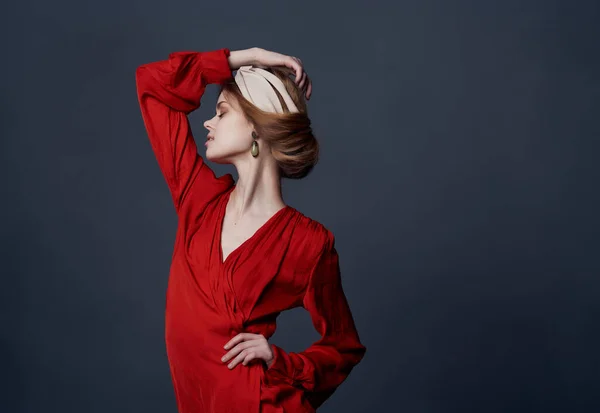 Mulher em vestido vermelho headband posando estilo elegante fundo escuro — Fotografia de Stock