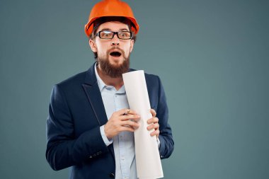 Erkek mühendis belgeleri elinde ve koruyucu üniforma çiziyor.