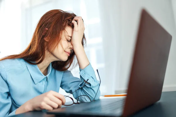 疲惫不堪的女人坐在笔记本电脑前的桌子前，工作上的不满情绪 — 图库照片
