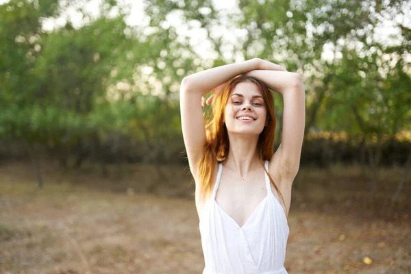 Fröhliche Frau im weißen Kleid draußen auf dem Feld Freiheitlicher Spaziergang — Stockfoto