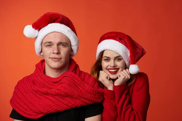 Engraçado homem e mulher natal santa chapéu amizade vermelho fundo — Fotografia de Stock