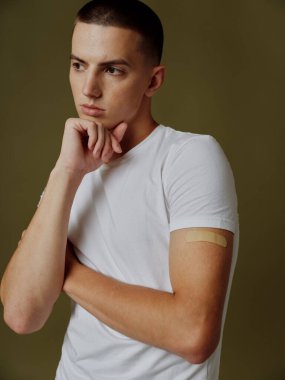 Omzunda yapıştırıcı olan beyaz tişörtlü bir adam pasaport enfeksiyonu modeli.