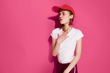 Pembe arka planda poz veren kırmızı şapkalı güzel bir kadın. Yüksek kalite fotoğraf