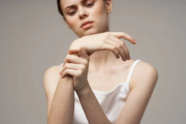 Vrouw in wit t-shirt gezondheidsproblemen gewrichten pijnbehandeling — Stockfoto