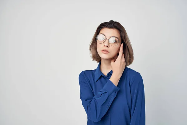Kvinna i blå skjorta bär glasögon elegant stil självförtroende studio — Stockfoto