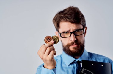 Kripto para birimi paralarıyla mavi gömlekli bir iş adamı. 