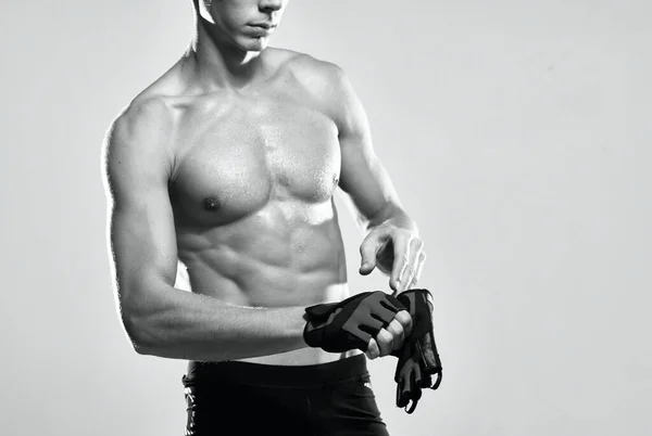 Atleta di sesso maschile in guanti sportivi pompato stampa allenamento fitness — Foto Stock