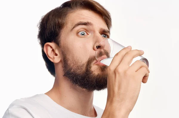 Mann im weißen T-Shirt trinkt Wasser isoliert Hintergrund — Stockfoto