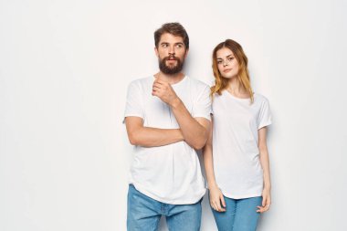 Beyaz tişört giyen kadın ve erkek gündelik kıyafetleri giyiyorlar.