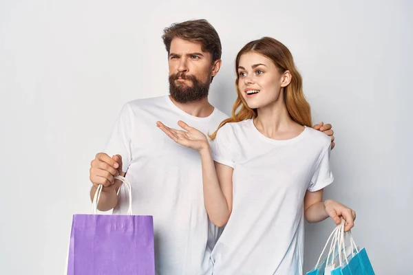 Joven pareja en t-shirts compras descuento venta divertido —  Fotos de Stock