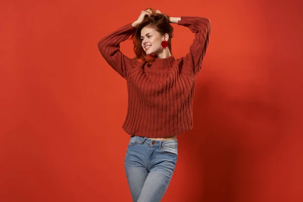 Γυναίκα σε κόκκινο πουλόβερ στούντιο μόδας ποζάροντας κόκκινο φόντο — Φωτογραφία Αρχείου