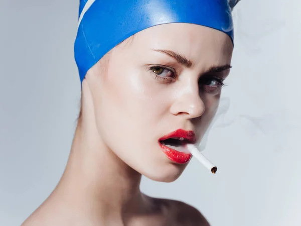 Mujer atlética con los hombros desnudos labios rojos fuma un cigarrillo aislado fondo — Foto de Stock
